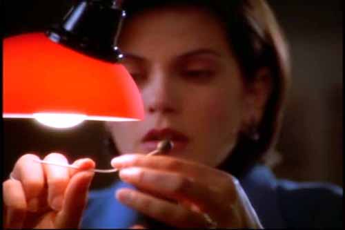Lois Lane examines a bokor Voodoo needle she picked up in Baron Sunday's airplane living quarters